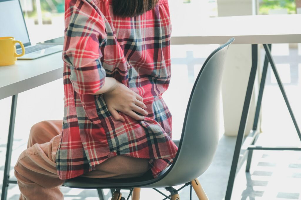Woman in Checkers Shirt With Back Pain