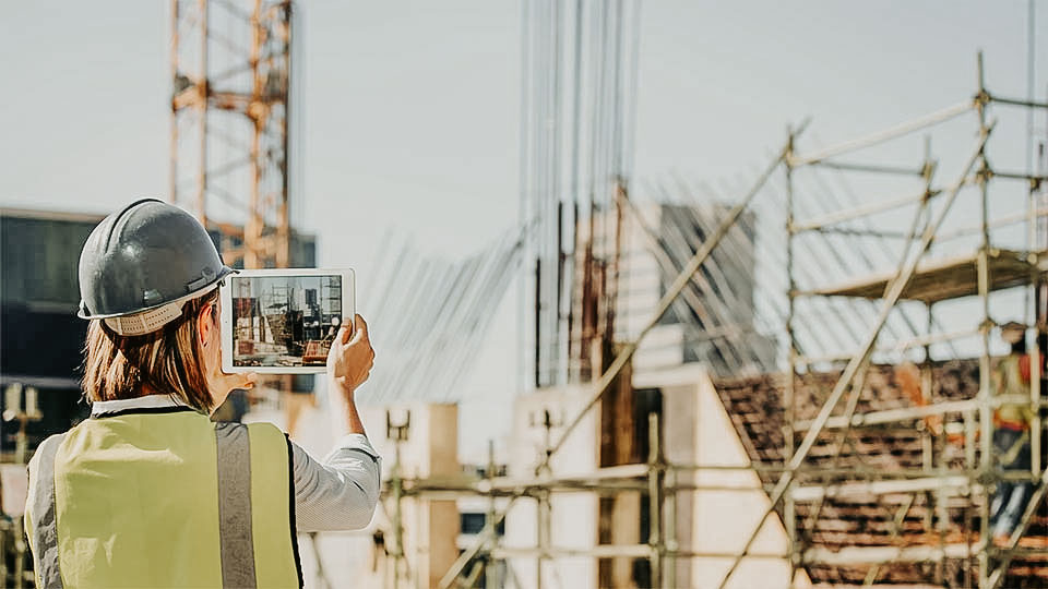 female construction worker taking picture with tablet device at a construction site