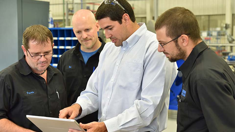Workers looking at a tablet in an industrial setting