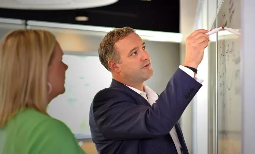 Man writing on white board