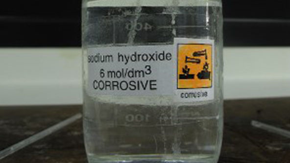 Bottle and pellets of sodium hydroxide - Stock Image - A500/0832