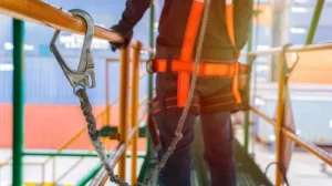 Worker wearing fall protection harness and lanyard