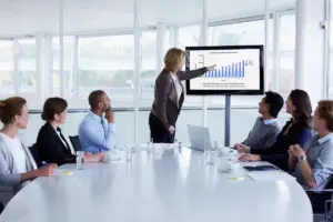 Woman presenting in front of a board of executives