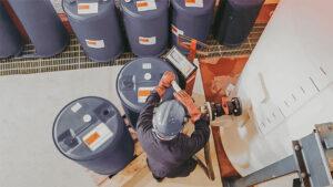 Chemical & SDS Management in the workplace. Chemical Management Worker filling a chemical container.