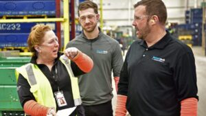 Human Tech Workers - Two men and a woman discussing ergonomics data via tablet