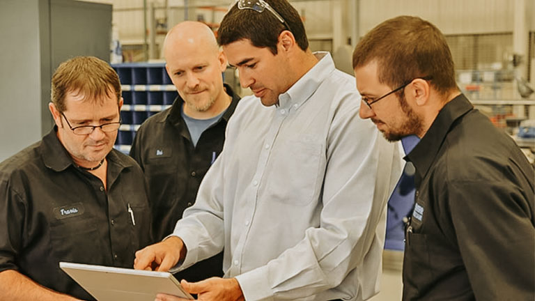 Workers looking at a tablet in an industrial setting