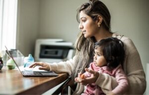Mother working from home with child on lap