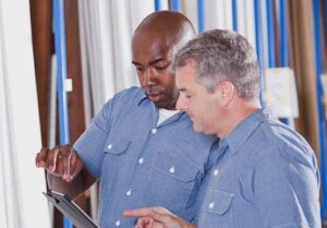 two men with tablet device