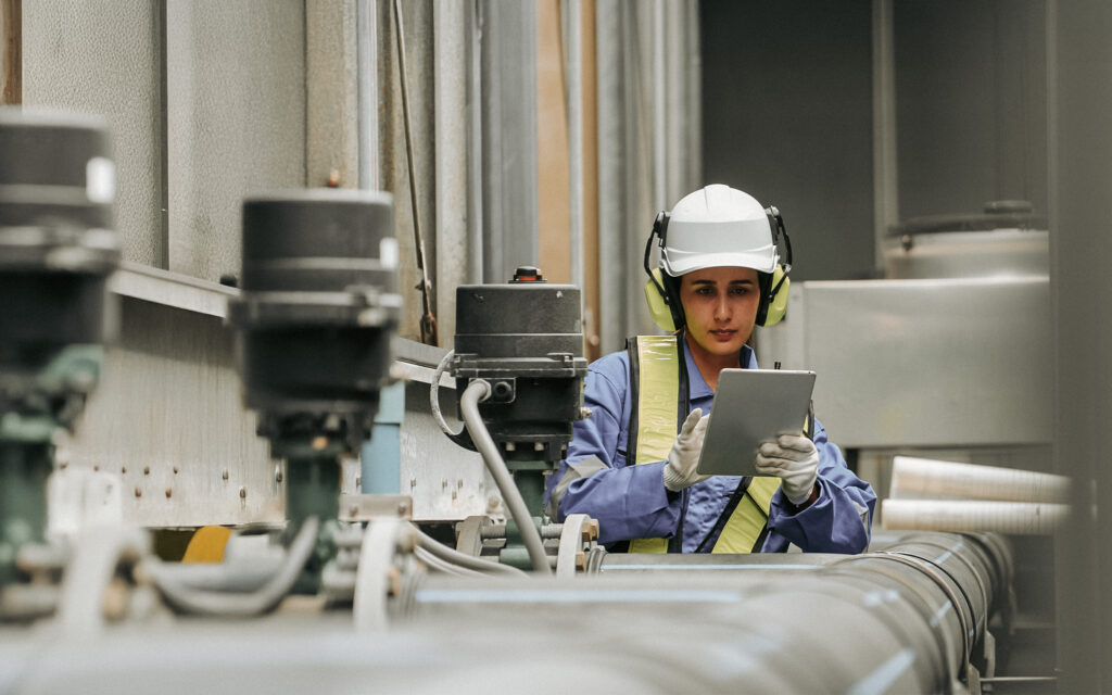 Worker using mobile device in industrial setting
