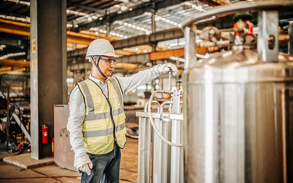 Asian Worker Operating A Gas Tank In A Factory