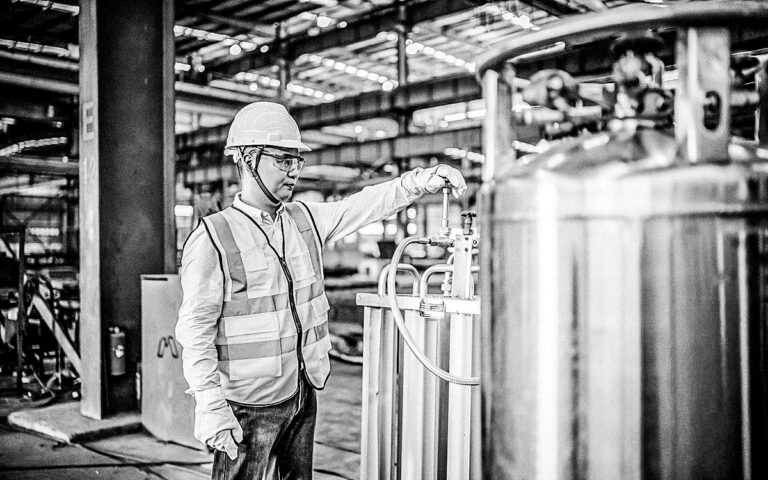 Asian Worker Operating A Gas Tank In A Factory