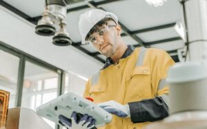 Engineer Working With Robotic Arm At Industrial Manufacturing.