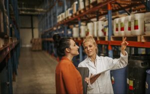 Chemical Management Two Workers Reviewing Stored Containers In A Warehouse 681900191 1200x750