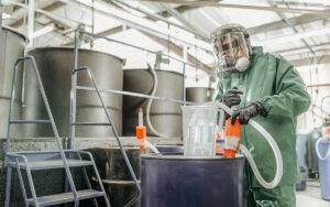 Worker Filling Jug With Chemical In Chemical Factory