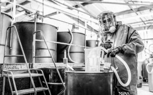 Worker Filling Jug With Chemical In Chemical Factory