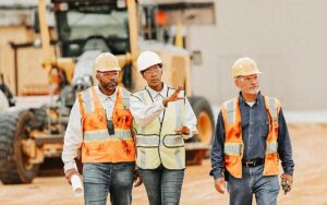Woman Directing Construction Workers, Walking Thru Site