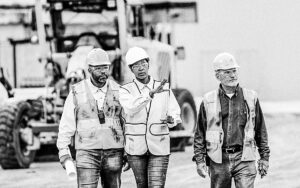 Woman Directing Construction Workers, Walking Thru Site