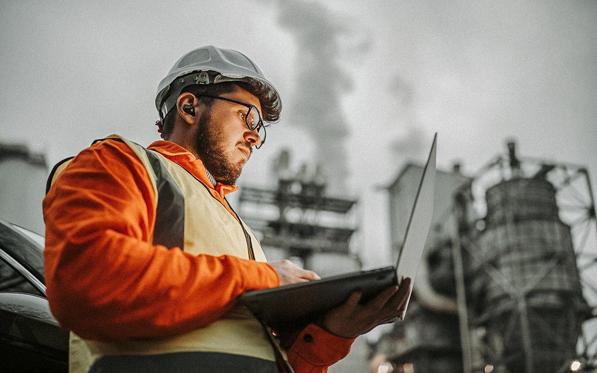Serious Handsome Engineer Using A Laptop While Working In The Oil And Gas Industry.