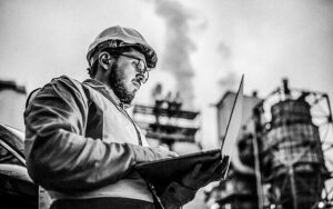 Serious Handsome Engineer Using A Laptop While Working In The Oil And Gas Industry.