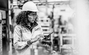 Managing Operations In Real Time By Using Shop Floor Control Management System. Female Production Engineer Using Tablet To Review Production Order Release And Capacity Of Machine Requirements In A Production Line.