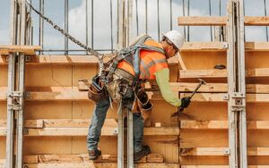 Caucasian Worker Hammering Wood At Construction Site