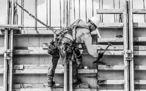 Caucasian Worker Hammering Wood At Construction Site