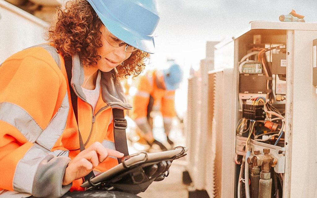Female Electrician With Aircon Unit